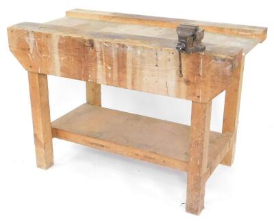 A pine work bench with a vice, and under tier, 84cm high, 122cm wide, 62.5cm deep.