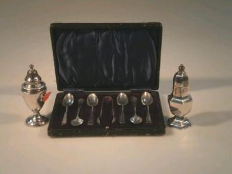Two silver pepper pots and a cased set of six coffee spoons and sugar nips