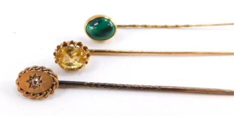 Three Victorian tie pins, one set with a rose cut diamond, another with a tourmaline, the third with a cabochon, malachite set in yellow metal.