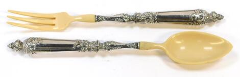 A pair of Continental faux ivory salad servers, with white metal handles embossed with flowers and foliate scrolls.