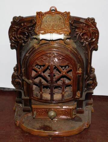 A French late 19thC La Minerva cast iron and brown enamel fire, by Allez Fres, Paris., of bow fronted form, with moulded foliate decoration, raised on a shaped hearth, 72cm high, 58cm wide, 52cm deep.