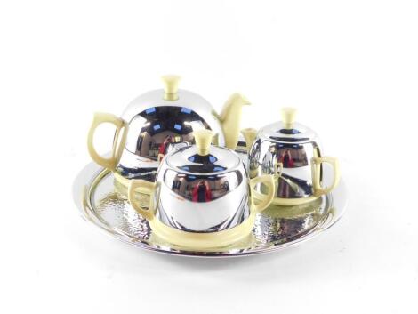 A mid century Heatmaster four piece tea set, yellow glazed with chrome covers, comprising circular tray, teapot, milk jug and lidded sucrier.