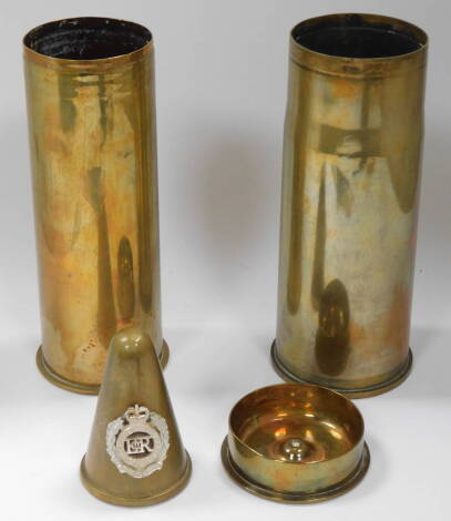 A German WWI shell case 1917, decorated with a lady, 'Peronne', an OKT 1917 shell case ashtray, a 76mm 1976 British shell case, and a Royal Engineers MkI No 5 shell cone, badge converted to a paperweight. (4)