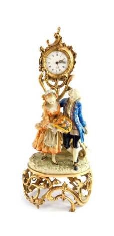 A French 20thC figural mantel clock, enamel circular dial bearing Roman and Arabic numerals, centre seconds, eight day movement with alarm, the case of brass rococo cast leaf scroll form, fronted by a pair of 18thC figures of a gallant and lady with a hat