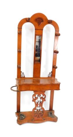 A Victorian oak hall stand, the double arched mirror inset back, with four turned hooks, above a serpentine box with umbrella recess to the left, over a carved and pierced vase shaped splat and serpentine base with two metal drip trays, 197cm high, 92cm w