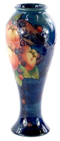 A Moorcroft pottery baluster shaped vase, decorated with pomegranates, birds, berries etc., impressed marks to underside, 28cm high.