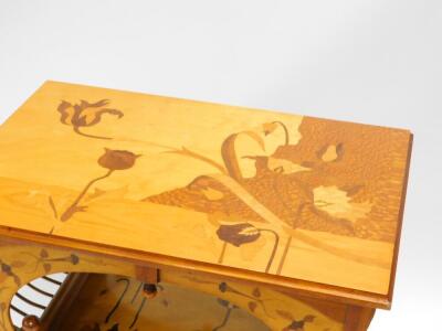 A marquetry two tier occasional table in the manner of Galle, the rectangular top inlaid with tulips, leaves, and other flowers in specimen timbers, on shaped supports with similar decoration to the undertier, with turned legs and H stretcher, 73cm high, - 2