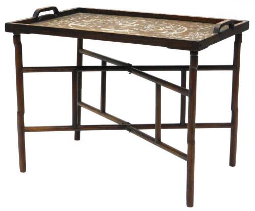 An oriental hardwood tray top table, with a raised gallery, inlaid with mother of pearl with figures, buildings, people fishing, fish, birds, etc., on a folding X shaped stand, the top 74cm x 51cm.