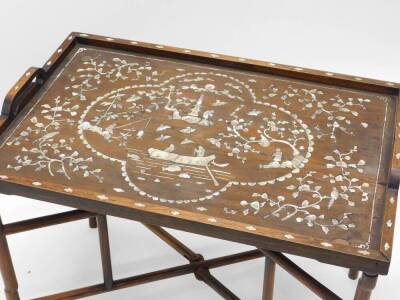 An oriental hardwood tray top table, with a raised gallery, inlaid with mother of pearl with figures, buildings, people fishing, fish, birds, etc., on a folding X shaped stand, the top 74cm x 51cm. - 2