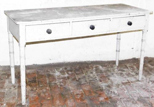 A Regency painted and simulated bamboo side table, with three frieze drawers having knob handles, 77cm high, 132cm wide, 54cm deep.