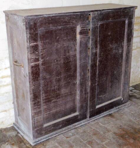 A 1930's mahogany housekeeper's cupboard, with two doors revealing a shelved interior on plinth base, 118cm high, 132cm wide, 42cm deep.