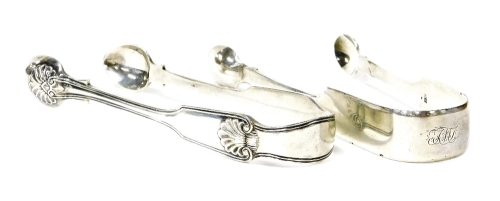 Two pairs of silver sugar tongs, one of plain design bearing the initials TMJ, London 1833 and another pair with shell cartouche decoration, London assay, 3½oz. (2)