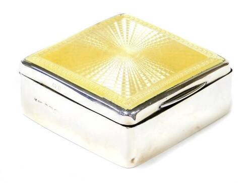 A George V silver and enamel cigarette box, the rectangular top with yellow enamelled decoration, lift up lid to a blue enamel interior and wooden panelling, hallmarks rubbed Birmingham 1926, 4¼ oz gross, 4.5cm high x 8cm wide.