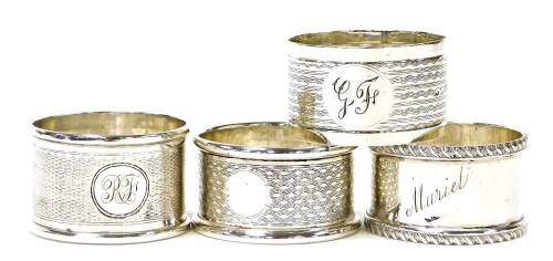 Four various silver napkin rings, comprising a napkin ring with engine turned decoration and bearing the initials GF, Birmingham 1945, another of engine turned decoration bearing the initials RF in a circular emblem, Birmingham 1916, another with ribbed b