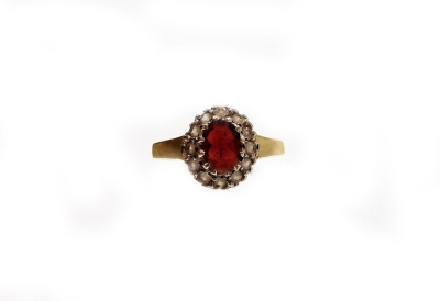 A 9ct gold dress ring, set with garnet and white stones, on shaped shoulders, ring size L, 2.8g all in. (boxed)