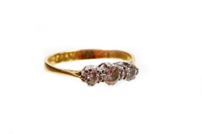 A diamond three stone ring, the three diamonds each in platinum setting totalling approximately 0.3ct overall, on a yellow metal band stamped 18ct, ring size K½, 2.1g all in, boxed.