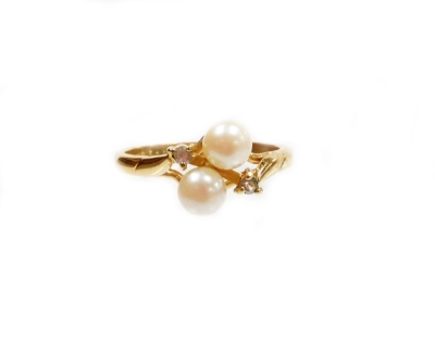 A faux pearl and imitation white stone set dress ring, of twist design on a yellow metal coloured band gold plated, unmarked, ring size M.