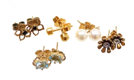 A group of 9ct gold and other earrings, to include a pair of 9ct gold cultured pearl studs, pair of 9ct gold aquamarine earrings, a pair of yellow metal floral cluster earrings, a pair of 9ct gold floral cluster and blue stone set earrings. (5 pairs)