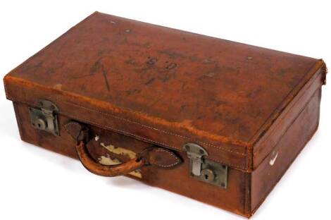 An early 20thC leather suitcase, with the initials GS and handwritten name GP Stow to inside, with various partial labels, 18cm high, 56cm wide, 32cm deep.