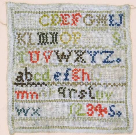 An early 20thC needlework sampler, depicting the alphabet and numbers one to five, 14cm x 14cm, in a modern wooden frame.