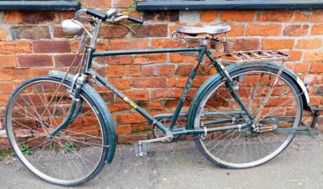 A Goldline Super Atlas gentlemans bicycle, on green metal frame, with bell and bicycle lamp, on a Brooks India seat.