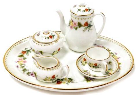 A Wedgwood miniature dolls tea service, comprising serving tray, tea pot, milk jug, sugar bowl and cup and saucer, in a floral design, 18cm wide.