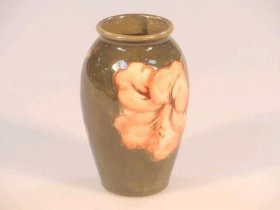 A small Moorcroft ovoid vase with hibiscus decoration on a green ground