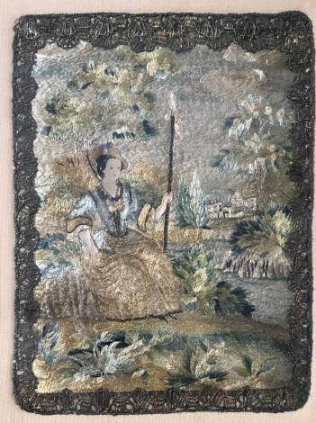 A Georgian petit point needlework silk picture, with silver filigree lacework border depicting a seated lady with crinoline dress and bonnet and buildings in the distance, 18cm x 14.5cm, gilt and glazed frame.