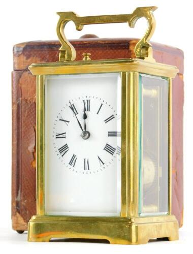 A brass carriage clock, with hour repeat, the white enamel dial with Roman numerals, the case with a swing handle, in leather travelling case with key, the clock 15cm high overall.