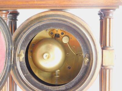 A late 19th/early 20thC French walnut portico clock, with a moulded top, reeded pillars supporting a clock with white enamel dial, Arabic numbers on a plinth with bun feet, 30cm high, 21cm wide. - 2