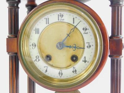 A late 19th/early 20thC French walnut portico clock, with a moulded top, reeded pillars supporting a clock with white enamel dial, Arabic numbers on a plinth with bun feet, 30cm high, 21cm wide. - 3