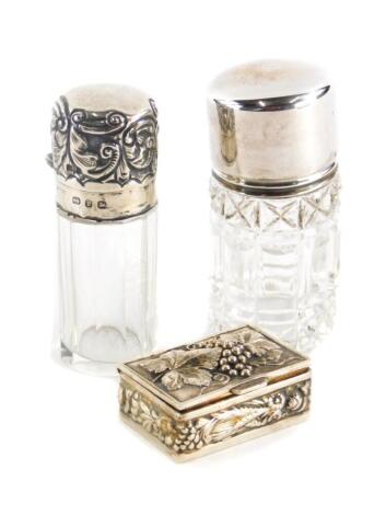 Two glass and silver topped scent bottles, to include a George VI cut glass example, Birmingham 1942, another the top cast with scrolls etc., Birmingham 1881, and a continental snuff box, raised with bunches of grapes, vines, leaves etc. (3)