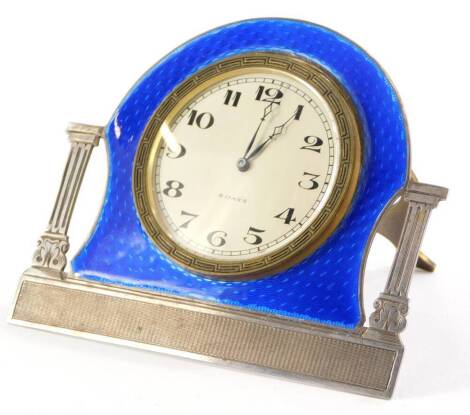 A George V silver and blue enamelled clock, by Alexander Clark and Co. ltd, with eight day movement, the dial flanked by classical pillars, with engine turned decoration, on easel stand, Birmingham 1929, 9cm high, 10cm wide.