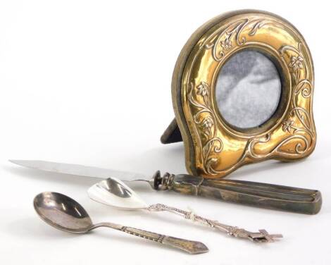 A collection of small silver and silver plate, to include a silver gilt photograph frame, 9cm wide, cast with flowers, leaves, etc., a spoon with hammered and bead decoration, fish knife, etc. (a quantity)