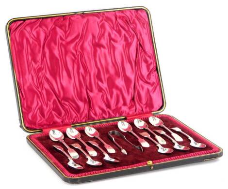 A set of twelve Edwardian silver spoons, fiddle pattern each engraved with the letter K, and a pair of silver sugar tongs, Sheffield 1904, 5¾oz, in a fitted box.