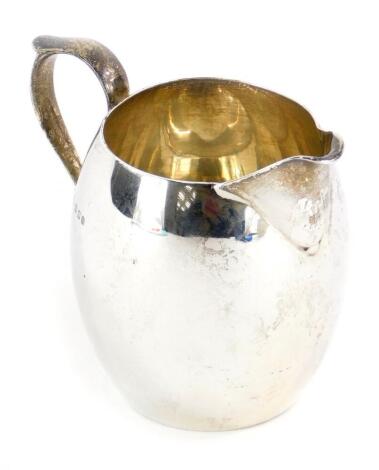 An Edwardian silver cream jug, of plain form, with thumb mount ear shaped handle, London 1908, 2¾oz, 9cm high.