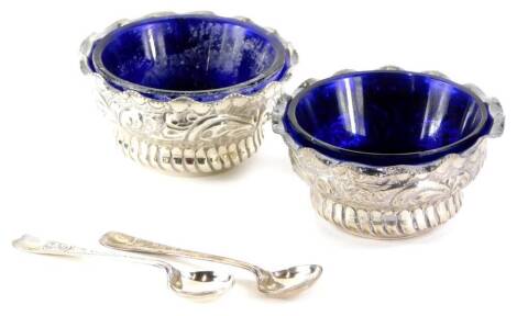 A pair of Victorian silver salts, with blue glass liners, cast with scrolls, leaves, etc., Birmingham 1898, 6cm wide, and two silver salt spoons, Birmingham 1905, weighable silver 1¼oz without liners.