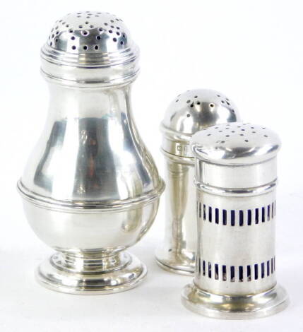 An Edwardian silver baluster shaped pepper pot, London 1906, 9cm high, and a pair of smaller pepper pots with pierced sides and blue glass liners, weighable silver 3oz. (3)