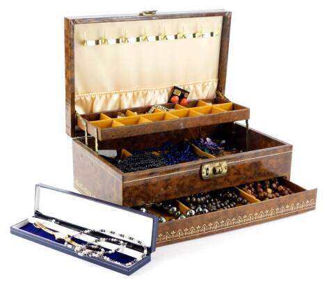 A brown faux leather jewellery box and contents, comprising of wooden beaded necklaces, various other beaded necklaces, brooches, clip on earrings, hoop earrings, wristwatch, etc. (a quantity)