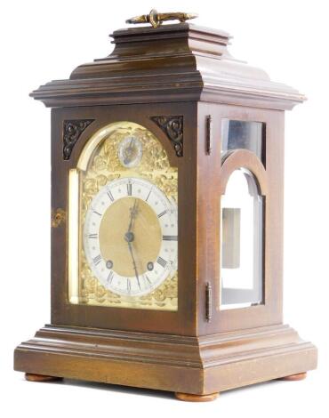 A 20thC mahogany mantel clock, the arched dial with applied rococo scroll spandrels, a regulator dial and a silvered chapter ring, German movement, 42cm high.