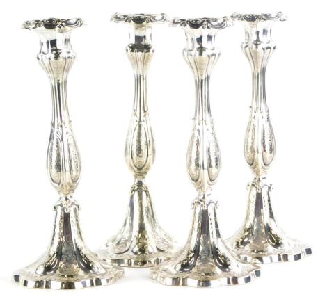 A set of four continental silver plated candlesticks, each with embossed and engraved decoration of scrolls, leaves, etc., 28cm high.