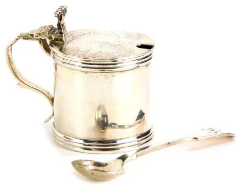 A George VI silver mustard pot, of cylindrical form, with angular ear handle and scroll decoration, lacking blue glass liner, 7cm high, London 1937, and a silver fiddle pattern mustard spoon with bee monogram to handle, weighable silver 2¨öoz.