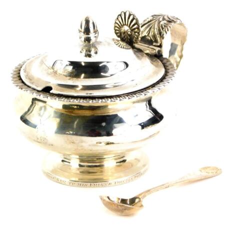 A George III Newcastle silver mustard pot, with stylized leaf border, the handle raised with leaves, etc., possibly 1806, date mark rubbed, 7cm high, with clear glass liner and silver mustard spoon, Birmingham 1994, weighable silver 4½oz.