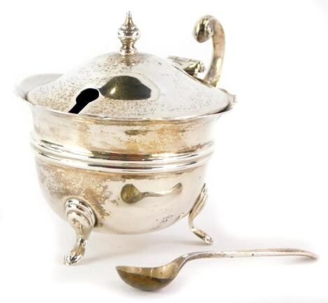 A George VI silver mustard pot, with stylized ear handle and blue glass liner, Sheffield 1946, and a silver salt spoon, weighable silver 1¼oz.