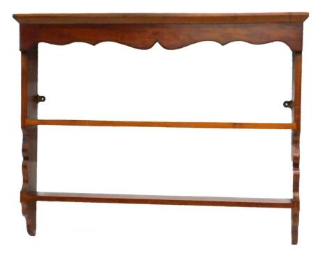 A mahogany wall shelf, with a moulded cornice above a shaped apron and two shelves, 72cm high, 93cm wide.