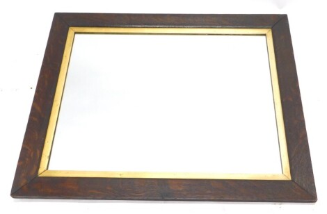 A plain oak wall mirror, with a parcel gilt border, 70cm x 64cm.