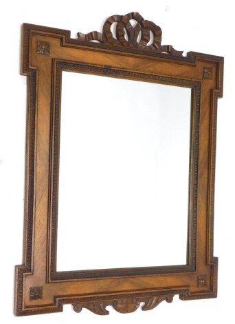 A continental mahogany wall mirror, with a pierced ribbon carved crest, above a rectangular plate, 79cm high, 59cm wide.