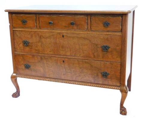 A continental walnut commode, the top with a moulded edge above three frieze drawers and two further long drawers, with a gadrooned apron and cabriole legs with ball and claw feet, 88cm high x 112cm wide, 56cm deep.