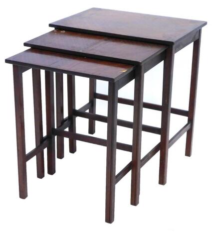 A nest of three mahogany tables, each with a quarter veneered top, on plain supports, the largest 48cm wide.