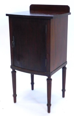 An Edwardian mahogany and ebony strung bow fronted pot cupboard, with a raised back, with a plain door, enclosing a shelf with slatted back, on part turned and reeded legs, 83cm high, 41cm wide.